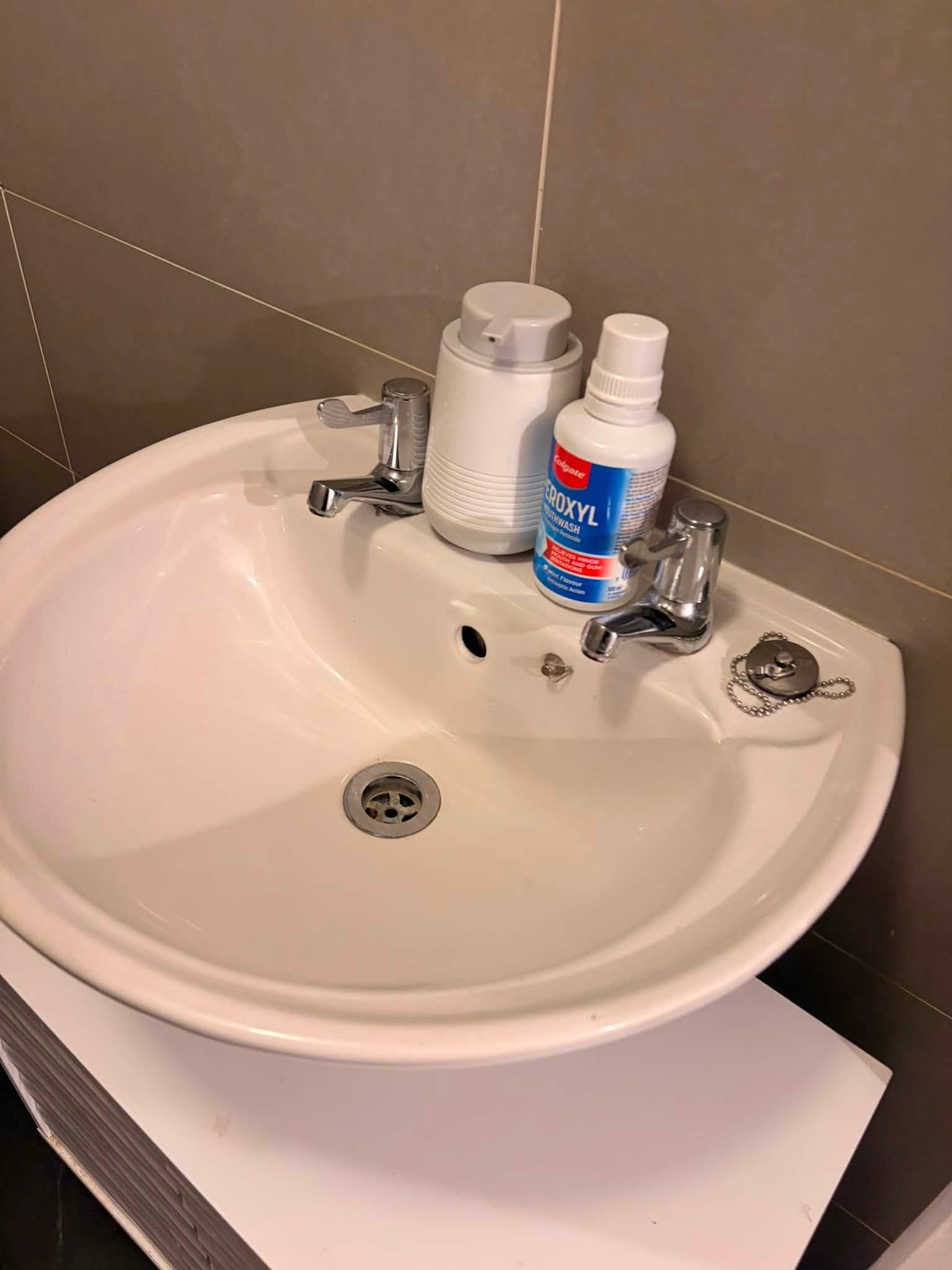 The same bathroom sink after cleaning, clear and spotless